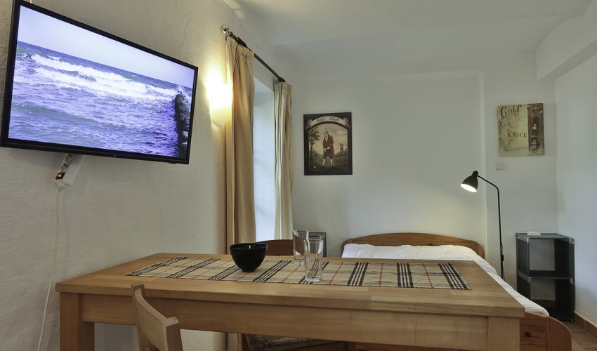 Essbereich mit Bett im Hintergrund